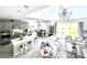 Open-concept living area featuring a kitchen, dining area, and living room with large windows at 33560 Castaway Loop, Wesley Chapel, FL 33543