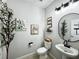 Well-lit powder room featuring a pedestal sink, neutral walls, and modern fixtures at 33560 Castaway Loop, Wesley Chapel, FL 33543