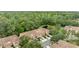Aerial view of townhomes surrounded by lush greenery, trees, and ponds at 4149 Winding River Way, Land O Lakes, FL 34639