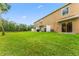 View of a large grass backyard with a pond in the distance at 4149 Winding River Way, Land O Lakes, FL 34639