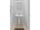 Well-lit pedestal sink and square mirror in half bath/powder room at 4149 Winding River Way, Land O Lakes, FL 34639