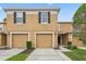 Townhome exterior with a two-car garage and neatly manicured landscaping at 4149 Winding River Way, Land O Lakes, FL 34639