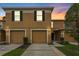 Townhome exterior features a two-car garage and well-maintained landscaping at 4149 Winding River Way, Land O Lakes, FL 34639