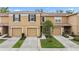 Tan townhome featuring attached garages, a manicured lawn, and welcoming curb appeal at 4149 Winding River Way, Land O Lakes, FL 34639