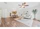 Open-concept living room features wood floors, stylish decor, ceiling fan, and easy access to the kitchen and dining area at 4149 Winding River Way, Land O Lakes, FL 34639