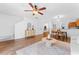 Living room boasts an open-concept layout with wood floors, a modern ceiling fan, and access to the kitchen and dining area at 4149 Winding River Way, Land O Lakes, FL 34639