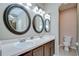 Bathroom featuring dual sinks with dark wood vanity and bright lighting with toilet at 4227 Bethpage Ct, Wesley Chapel, FL 33543