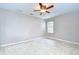 Neutral bedroom features a ceiling fan and window allowing ample natural light to flow in at 4227 Bethpage Ct, Wesley Chapel, FL 33543