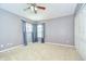 Bedroom with large windows and a ceiling fan that provide natural light at 4227 Bethpage Ct, Wesley Chapel, FL 33543