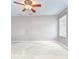 Spacious carpeted bedroom featuring a ceiling fan and large window providing lots of natural light at 4227 Bethpage Ct, Wesley Chapel, FL 33543