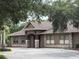 Community clubhouse featuring stone accents, neutral paint, shutters, with a covered entryway and landscaping at 4227 Bethpage Ct, Wesley Chapel, FL 33543