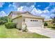 Exterior view of the home, displaying the lawn, landscaping, and two-car garage at 4227 Bethpage Ct, Wesley Chapel, FL 33543