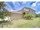 Exterior view of home showing lawn, landscaping, palm trees, and an arched entrance at 4227 Bethpage Ct, Wesley Chapel, FL 33543