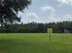 Vast grassy field with mature trees, attention sign and soccer nets at a community sports complex at 4227 Bethpage Ct, Wesley Chapel, FL 33543