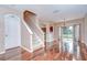 Bright living room features hardwood floors, staircase, chandelier, and sliding doors leading to backyard at 4227 Bethpage Ct, Wesley Chapel, FL 33543