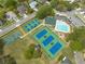 Aerial view of community pool, basketball court, tennis courts, and surrounding neighborhood at 4228 Silver Star Dr, Spring Hill, FL 34609