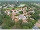 Expansive aerial view of a residential community with mature trees and a pond creating a serene neighborhood atmosphere at 4228 Silver Star Dr, Spring Hill, FL 34609