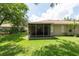 Expansive backyard with lush lawn, mature trees, and a screened-in porch at 4228 Silver Star Dr, Spring Hill, FL 34609
