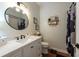 Bright bathroom features a stylish round mirror, white vanity, and modern fixtures at 4228 Silver Star Dr, Spring Hill, FL 34609
