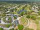 Aerial view of a golf course with mature trees and a clubhouse creating a picturesque and inviting recreation space at 4228 Silver Star Dr, Spring Hill, FL 34609