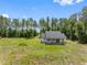 An aerial view reveals the home nestled among tall trees, showing its secluded location with ample green space at 4261 Burns Rd, Brooksville, FL 34602