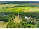High aerial view of property set in green landscape near large fields, under a clear blue sky at 4261 Burns Rd, Brooksville, FL 34602