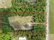 An aerial shot shows the location of the home on a large lot surrounded by lush greenery and a nearby road at 4261 Burns Rd, Brooksville, FL 34602