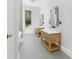 Bathroom featuring double vanities with marble countertops, wood cabinets, and modern mirrors providing a luxurious feel at 4261 Burns Rd, Brooksville, FL 34602
