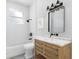 A bathroom vanity with marble countertop with a dark framed mirror and three sconce lighting fixture at 4261 Burns Rd, Brooksville, FL 34602
