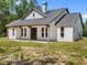 Charming single-story home with farmhouse design, wood porch, and dark gray roof at 4261 Burns Rd, Brooksville, FL 34602
