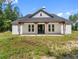 Charming exterior featuring a covered front porch with wooden beams and a modern black front door at 4261 Burns Rd, Brooksville, FL 34602