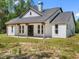 Striking front elevation featuring a welcoming porch, black-framed windows, and contemporary white siding at 4261 Burns Rd, Brooksville, FL 34602