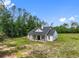 Exterior angle of the house showing the porch, white siding, and surrounding landscape under a clear sky at 4261 Burns Rd, Brooksville, FL 34602