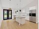Elegant kitchen with white cabinets, an island, stainless steel appliances, and natural light from a double door to outside at 4261 Burns Rd, Brooksville, FL 34602