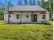 The rear of the house shows a simple, clean design with an inviting porch and well-maintained grassy surroundings at 4261 Burns Rd, Brooksville, FL 34602