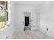 An unfinished room with smooth white walls with a large window and a doorway to another room at 4261 Burns Rd, Brooksville, FL 34602