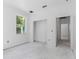 An open room with a large window bringing in ample natural light and bare white walls ready for customization at 4261 Burns Rd, Brooksville, FL 34602