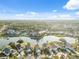 Breathtaking aerial view of homes nestled around a lake, with trees and a pool at 4411 Whitton Way, New Port Richey, FL 34653