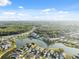 Scenic aerial view showcasing homes nestled around a serene lake with wooded areas at 4411 Whitton Way, New Port Richey, FL 34653