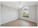 Empty bedroom with wood floors, large window, and ceiling fan at 4411 Whitton Way, New Port Richey, FL 34653