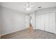 Empty bedroom with wood floors, closet, and ceiling fan with access to shared bathroom at 4411 Whitton Way, New Port Richey, FL 34653