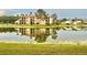 View of community apartments reflecting off the nearby scenic lake at 4411 Whitton Way, New Port Richey, FL 34653