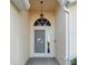 Charming front entrance with a dolphin themed security screen door and decorative transom window at 4411 Whitton Way, New Port Richey, FL 34653