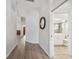 Open hallway featuring updated wood-look floors leading to a bathroom with white vanity at 4411 Whitton Way, New Port Richey, FL 34653