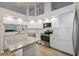 Modern kitchen with white cabinets, stainless steel appliances, and granite countertops at 4411 Whitton Way, New Port Richey, FL 34653