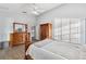 Large main bedroom with wood floors, ensuite bathroom, walk-in closet, ceiling fan and dresser at 4411 Whitton Way, New Port Richey, FL 34653