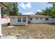 View of backyard with white home exterior, door to backyard and air conditioning unit at 4425 Porpoise Dr, Tampa, FL 33617