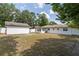 Backyard featuring a white house, a white shed, and a spacious, well-maintained lawn at 4425 Porpoise Dr, Tampa, FL 33617