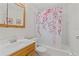 Bright bathroom featuring a single sink vanity and a tub with a decorative shower curtain at 4425 Porpoise Dr, Tampa, FL 33617