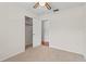 Neutral bedroom with a ceiling fan, carpet flooring, and an open closet with a door to the hallway at 4425 Porpoise Dr, Tampa, FL 33617
